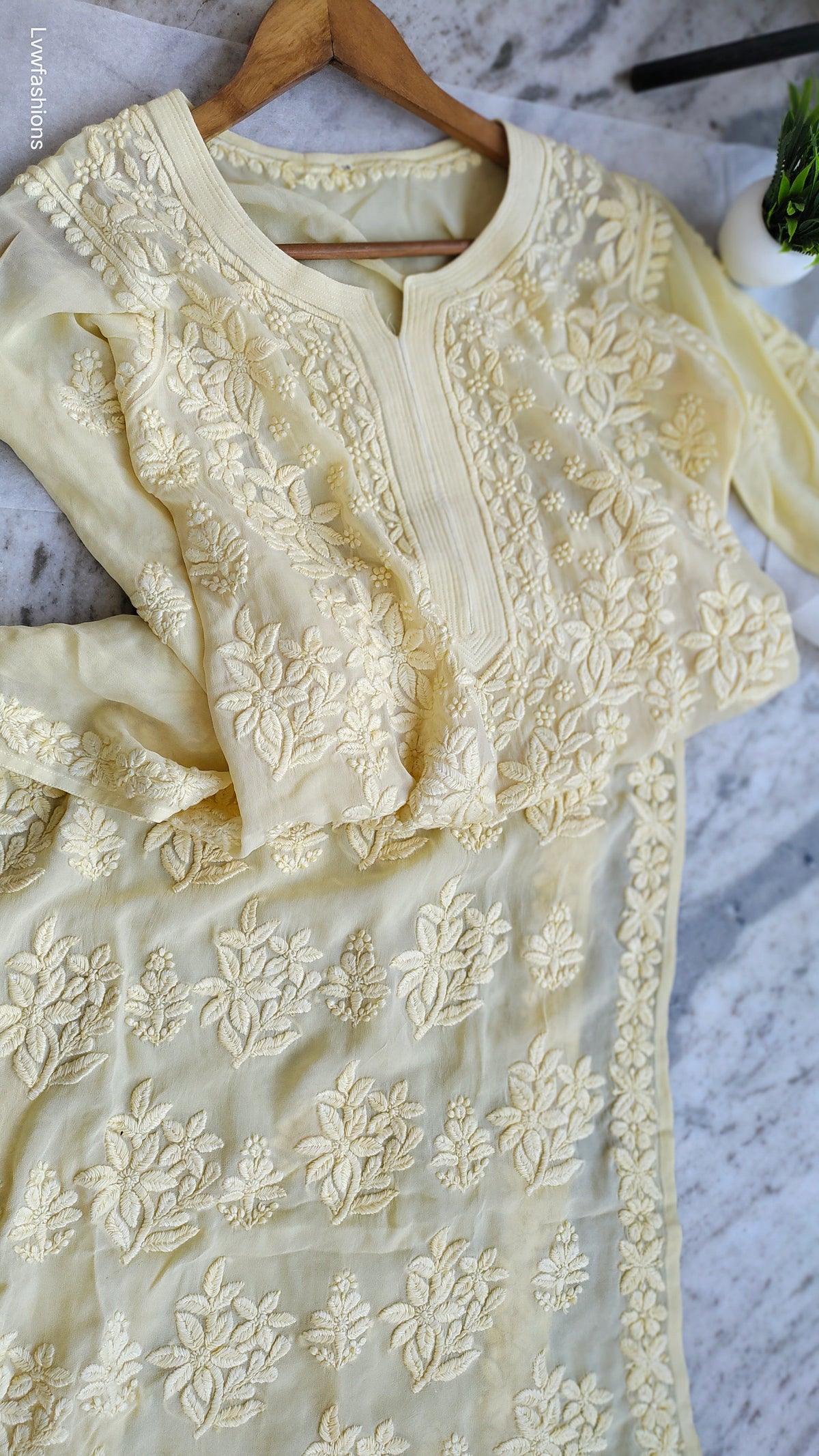 A pastel yellow georgette chikankari kurta with intricate white embroidery, handmade by LVW Fashions in Lucknow.
